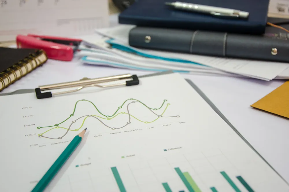 Printed financial charts and analysis report on a desk